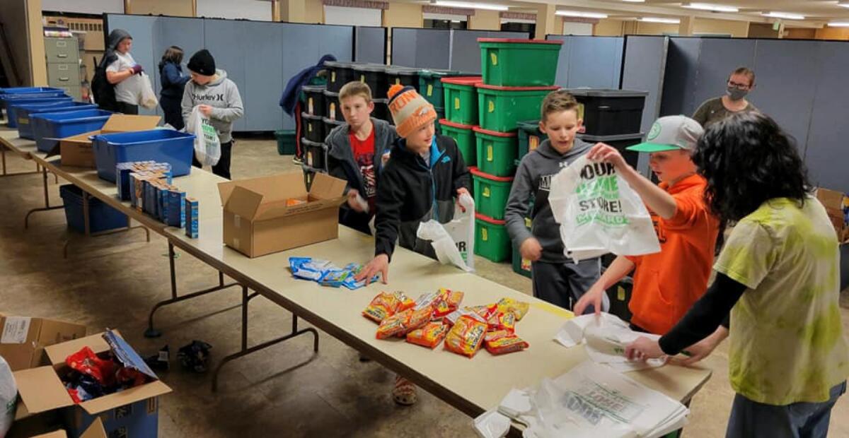 Students packing snacks for the backpack program